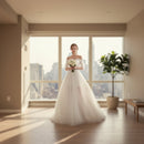 Woman in a white wedding dress holding flowers in a bright room with white curtains.