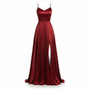 Red satin evening gown with a high slit on a white background
