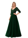 Woman wearing a green evening gown with sequin detailing in a room.